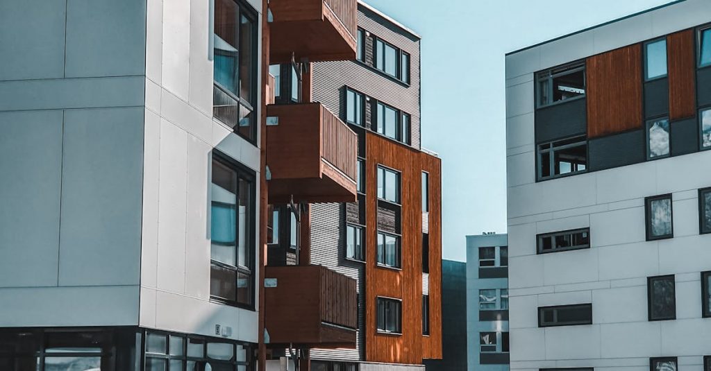 Contemporary apartment buildings with wooden accents in a snowy urban environment.