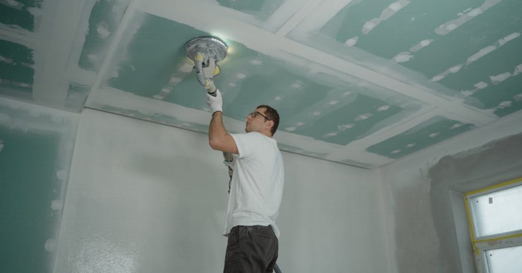 A worker expertly polishes a ceiling indoors, demonstrating home renovation skills.